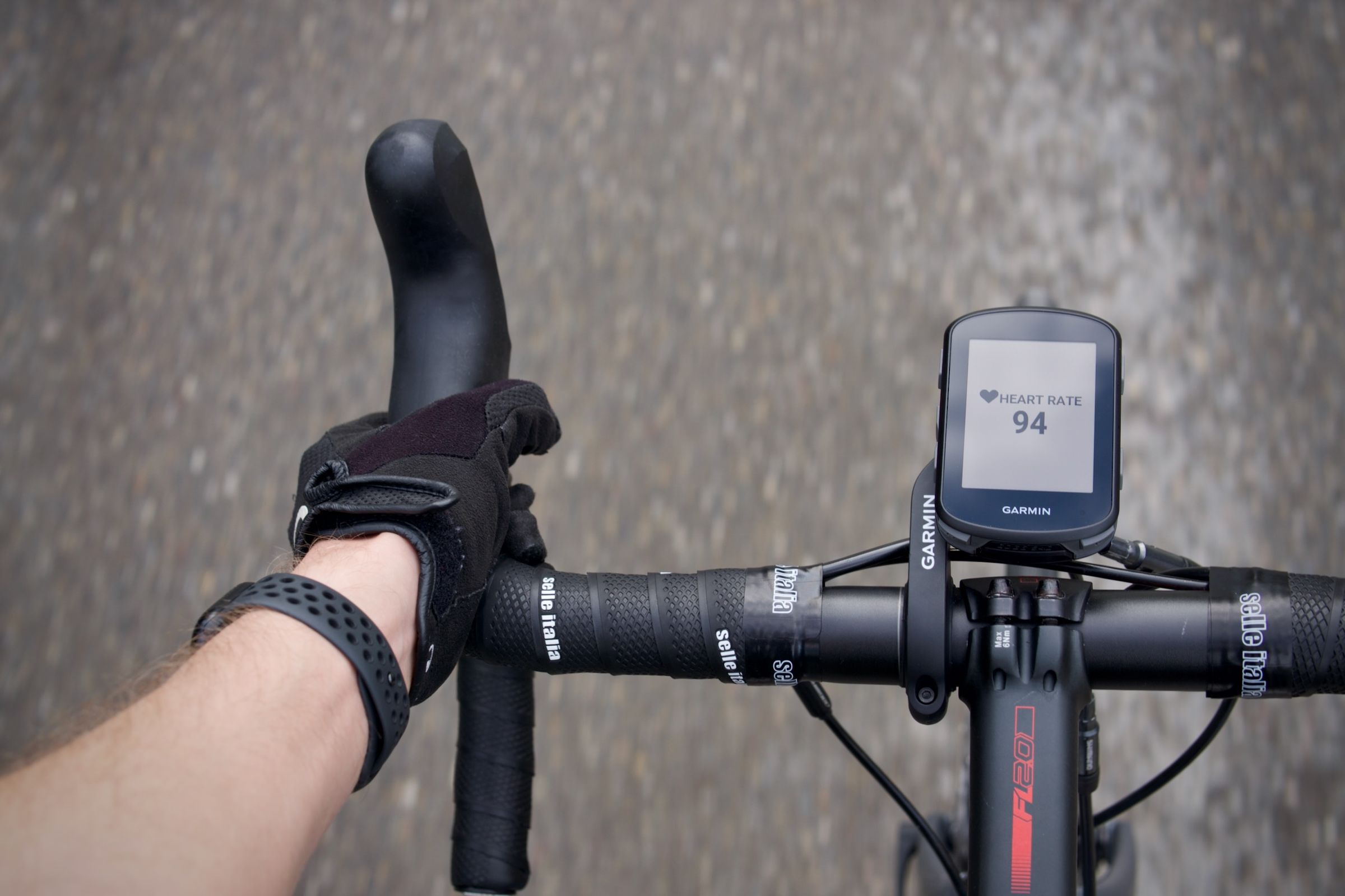 Garmin Edge mounted on handlebars showing live heart rate from Apple Watch via HRM app
